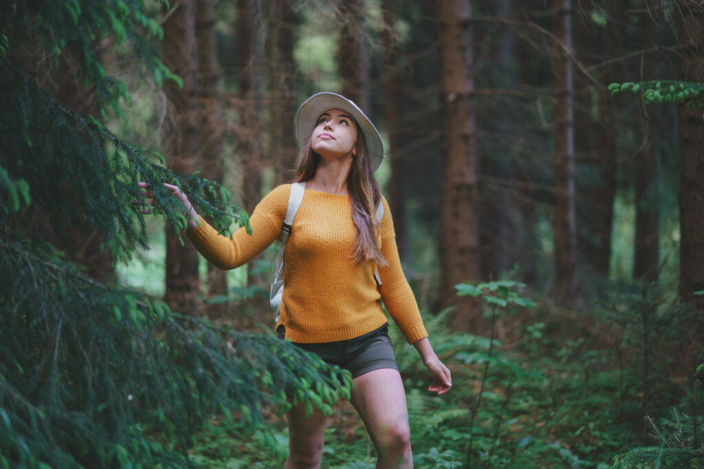 Young woman on a walk outdoors in forest in summer nature, walking.