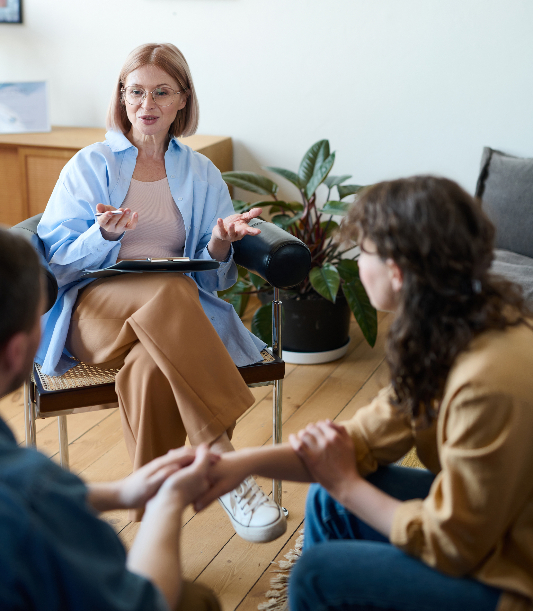 #our-therapeutic-approach-2 Mature psychotherapist talking to young couple at session, she discussing their problems and giving them advices SSUCv3H4sIAAAAAAAACpxSy47cIBC8R8o/jDgHCdwYw/5KlEPz8AxajxnZeKPVav497deIKLfc6OrqB1319f3b5cIczsmzt8vXGlGchmGZy4Ql5ZFg8ePApziGONXIxwRa1ACmOoohlTwlHGrQYfG3Ee+RwHEZhhV+bkk2FyzLHOdql/m2lBKnuWT/TrCs2B5LvFL7v/jnX37u8eVMbEmqoBRjxyr7gMVt2Antzf+rcn/8et3iGkf/ue72rLae4hBx/+OxI4smtn0rHY+tA6606LltO8OtDcFKIbwS7pzMnA0i+Gi4Aq2IHCyRe8M7GZRTTe+0Dy9yFAKsazsuQHVcNRCJ7BveWQO9DEY12L/IslMQnNBEFpY6W8FRtQ1HExrrQBrjzIsslAEdMXAdUHKFGrmVKLgBEWyvnDDQbJfZz8Hef5OK902p4xC4hJQr5T6yx2ElQHWtx5R8Gq9VWS63zYNnmc/LWKbPWh025PxAN6wO66lnPPEbzjPRw4nXZiLH53s1Z8xlE+noygK5bQ0lAEgw2hhlGmlaAQdhN+8tUZ9tnXPB5TFkDHEd+nLUP7bWRlsJorU7ozbMxkmhPl1am7Fe+g7QK1IpRq7IRdw20HIJ1nakSqt9TxI8/wAAAP//AwCSbMnK5QMAAA==