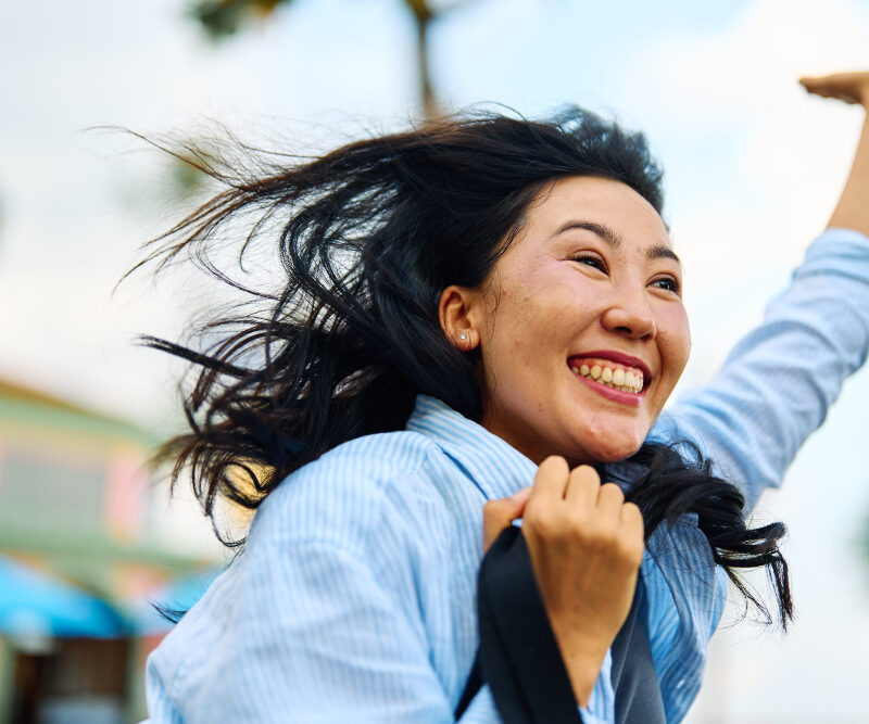 Portrait of a young woman girl running and waving in a rush , catching a taxi cab or meeting a friend