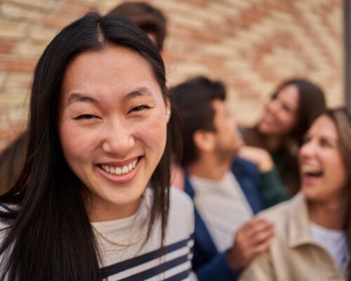 The woman smiles happily while sharing a fun moment with the group at the event