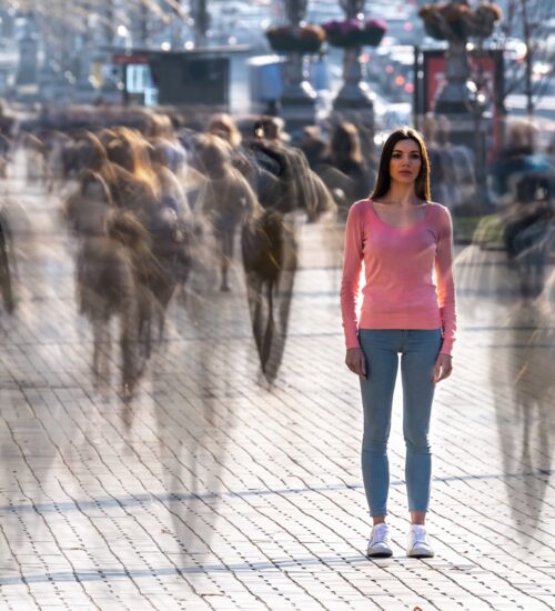 The young woman stands in the middle of crowded street
