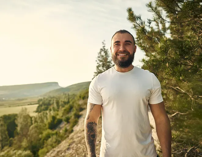 Man in white shirt on hike experiencing recovery through mental health treatment in greeley, colorado.