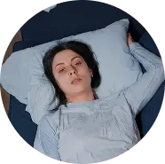A woman laying down in bed in need of mental health treatment in greeley, colorado.
