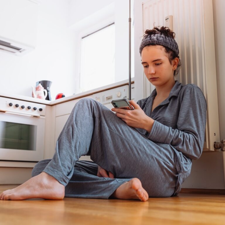 teenage-individual-sitting-indoors-using-a-phone-2026-01-08-06-43-09-utc